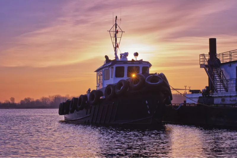 tug boat in front of a sunset